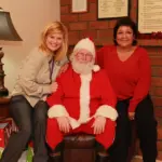 Santa sitting with 2 women