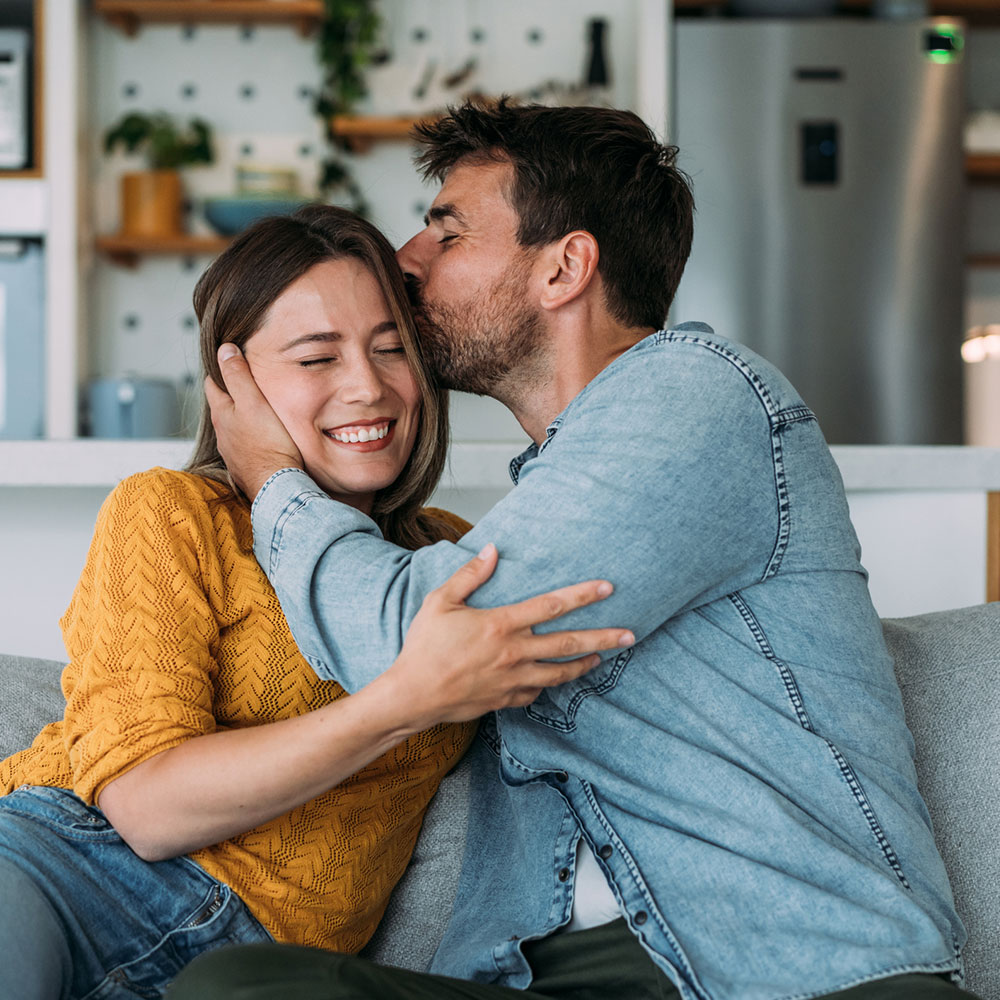 Man kisses his partner's head