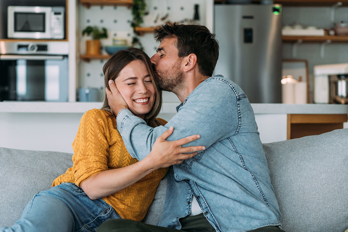 Man kisses his partner's head